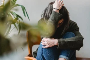 female sitting in a ball with co-morbid brain fog