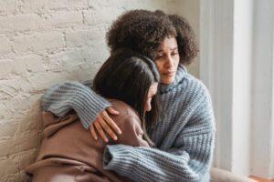 female hugging sad female