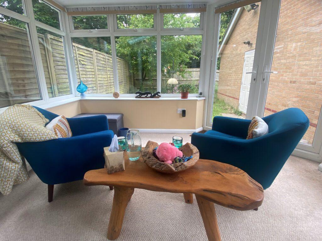 Counselling room with 2 chairs and a table, looking out over a garden